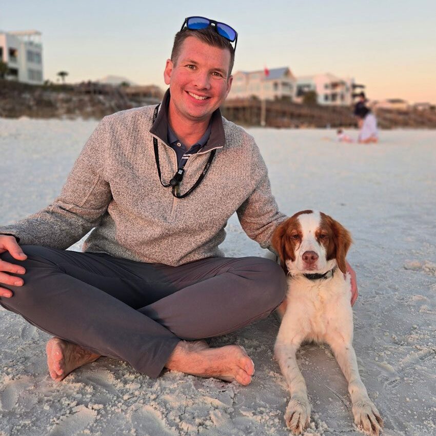 Dr. Knox With Dog Sitting On Beach